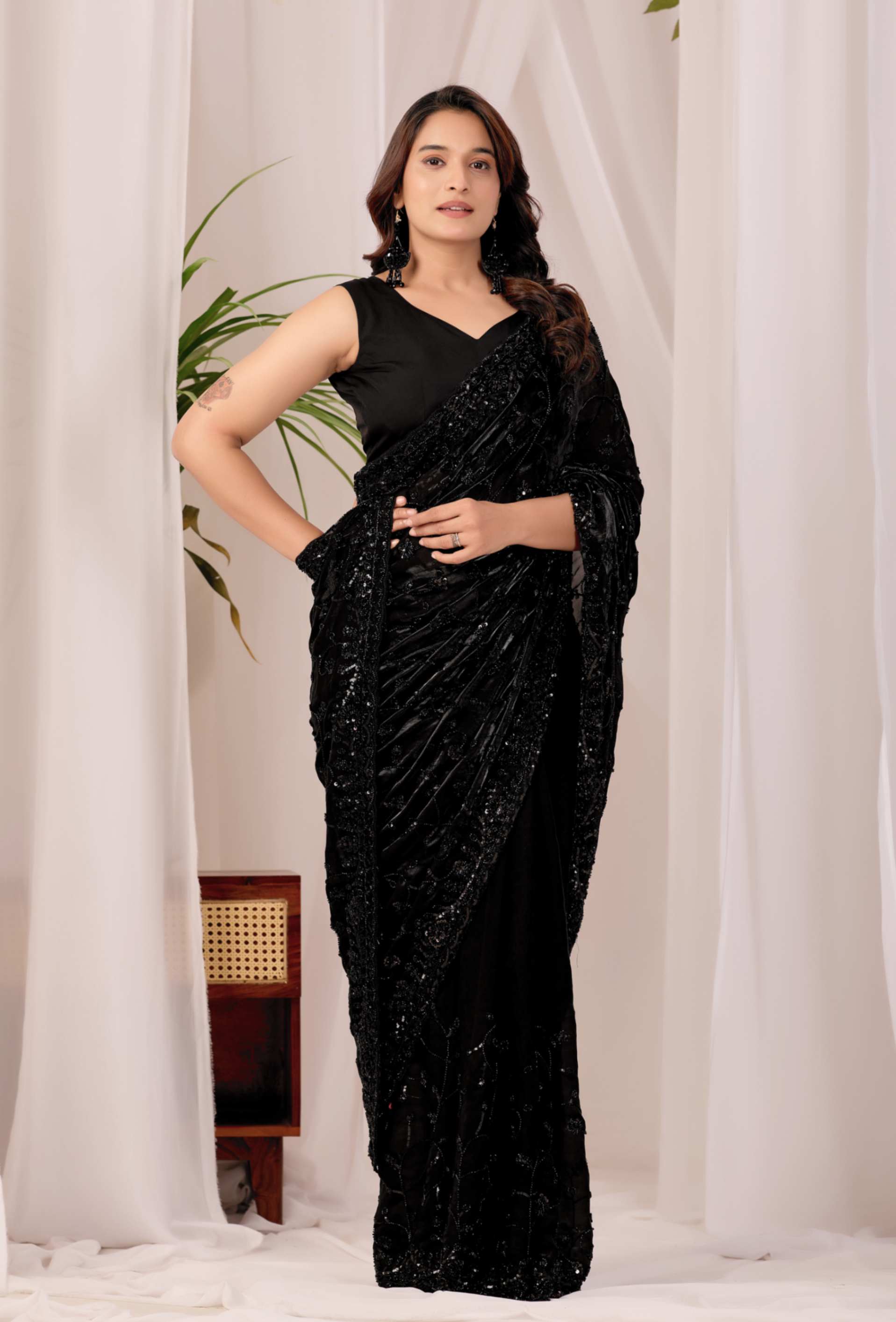 The Black Onyx Sequin Heritage Saree The Black Onyx Sequin Heritage Saree + Embrace the allure of the night with this stunning midnight onyx saree from Kesari Culture. This piece is a masterclass in monochrome elegance, featuring a luxurious black base completely transformed by shimmering tonal sequins. The intricate embroidery creates a subtle yet captivating texture that dances with the light, making it a sophisticated choice for cocktail parties, evening receptions, and high-glamour events. Paired with a sleek, sleeveless V-neck blouse, this ensemble offers a contemporary silhouette while maintaining the timeless grace of traditional attire.