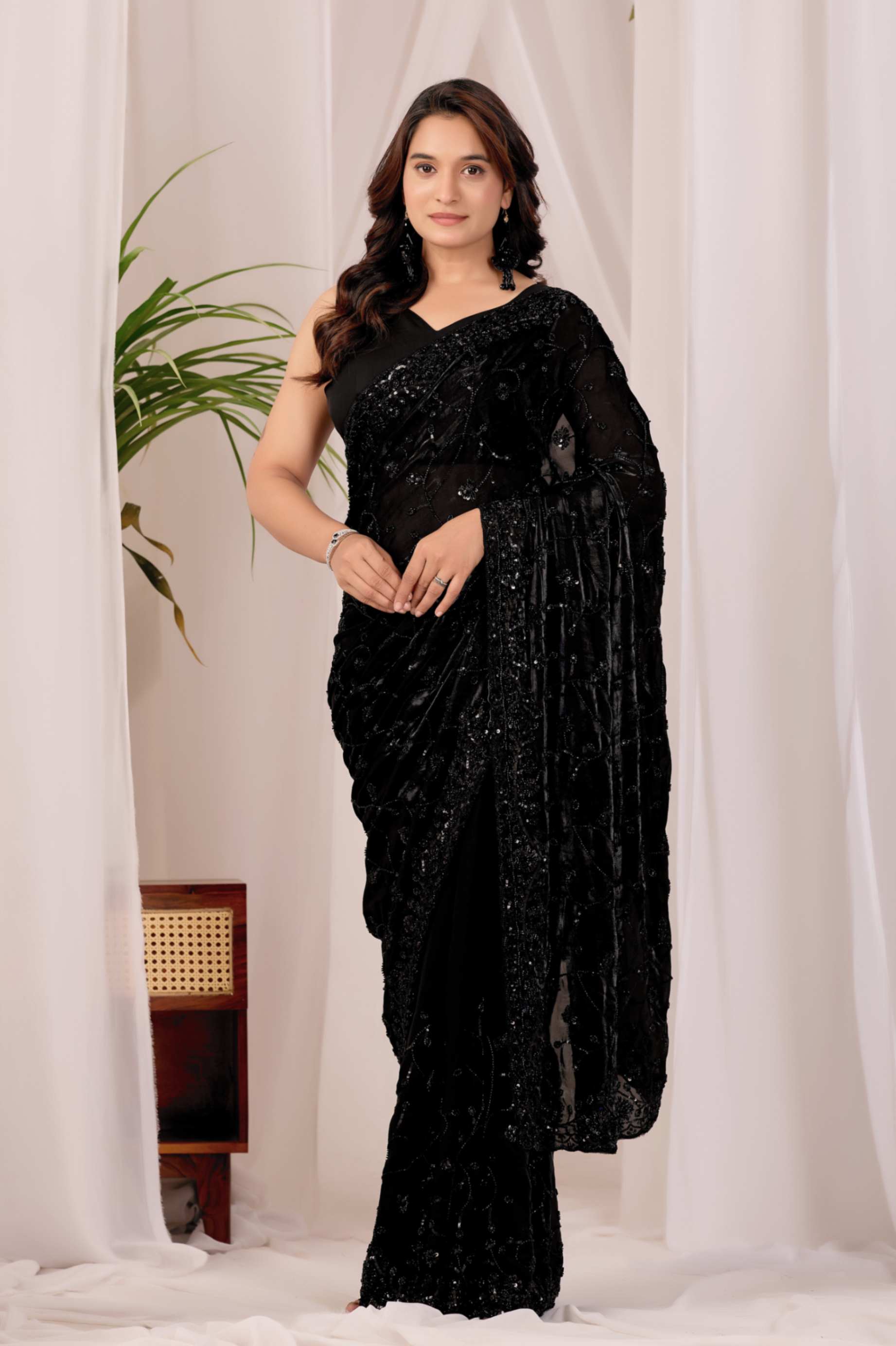 The Black Onyx Sequin Heritage Saree The Black Onyx Sequin Heritage Saree + Embrace the allure of the night with this stunning midnight onyx saree from Kesari Culture. This piece is a masterclass in monochrome elegance, featuring a luxurious black base completely transformed by shimmering tonal sequins. The intricate embroidery creates a subtle yet captivating texture that dances with the light, making it a sophisticated choice for cocktail parties, evening receptions, and high-glamour events. Paired with a sleek, sleeveless V-neck blouse, this ensemble offers a contemporary silhouette while maintaining the timeless grace of traditional attire.