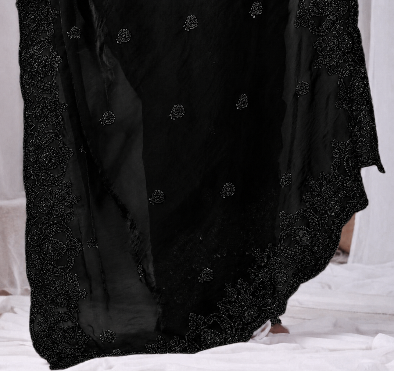 Black Tikki Moti Work Embroidered Designer Saree Black Tikki Moti Work Embroidered Designer Saree + ● The Black Tikki Moti Work Embroidered Designer Saree brings tikki (metallic sequin) and moti (pearl-bead) hand embroidery to a black base, and it's built for anyone comparing options for a black saree rather than something purely decorative. The colour reads true in both daylight and indoor event lighting, which matters more than it sounds &mdash; a lot of sarees photograph differently under venue lighting than they do in a product shot, and this one has been chosen to hold its tone consistently. ● Craftsmanship: The tikki pieces are stitched first to form the outline, then moti beads are layered in to add relief and shine, a slower two-step process than single-technique embroidery. This is what separates a black designer saree from a mass-printed alternative &mdash; the work is done by hand, so no two pieces are perfectly identical, and the detailing holds up to close inspection rather than only looking good from a distance.