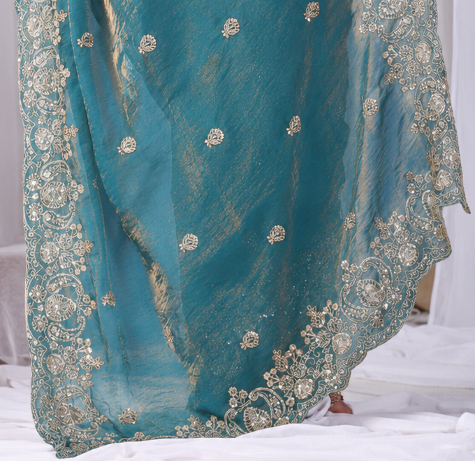 Teal Blue Tikki Moti Work Embroidered Designer Saree Teal Blue Tikki Moti Work Embroidered Designer Saree + The Teal Blue Tikki Moti Work Embroidered Designer Saree brings tikki (metallic sequin) and moti (pearl-bead) hand embroidery to a teal blue base, and it's built for anyone comparing options for a teal color saree rather than something purely decorative. The colour reads true in both daylight and indoor event lighting, which matters more than it sounds &mdash; a lot of sarees photograph differently under venue lighting than they do in a product shot, and this one has been chosen to hold its tone consistently. &bull; Craftsmanship