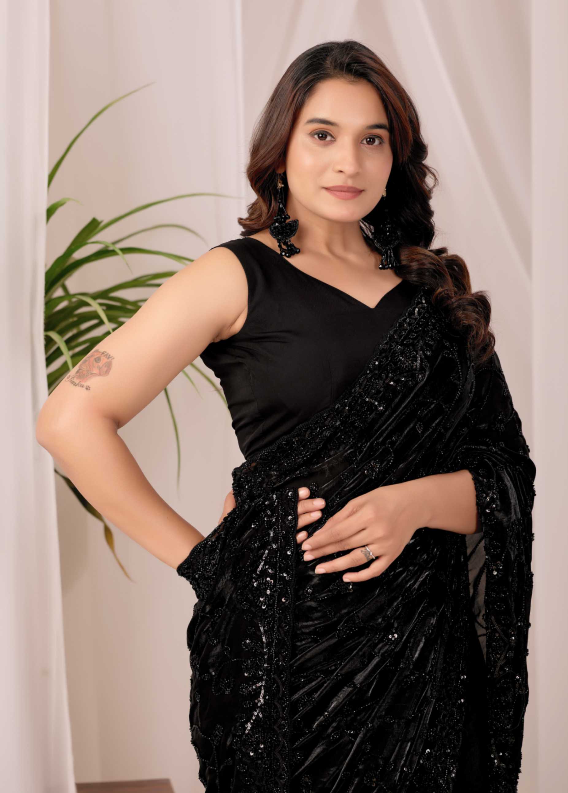 The Black Onyx Sequin Heritage Saree The Black Onyx Sequin Heritage Saree + Embrace the allure of the night with this stunning midnight onyx saree from Kesari Culture. This piece is a masterclass in monochrome elegance, featuring a luxurious black base completely transformed by shimmering tonal sequins. The intricate embroidery creates a subtle yet captivating texture that dances with the light, making it a sophisticated choice for cocktail parties, evening receptions, and high-glamour events. Paired with a sleek, sleeveless V-neck blouse, this ensemble offers a contemporary silhouette while maintaining the timeless grace of traditional attire.