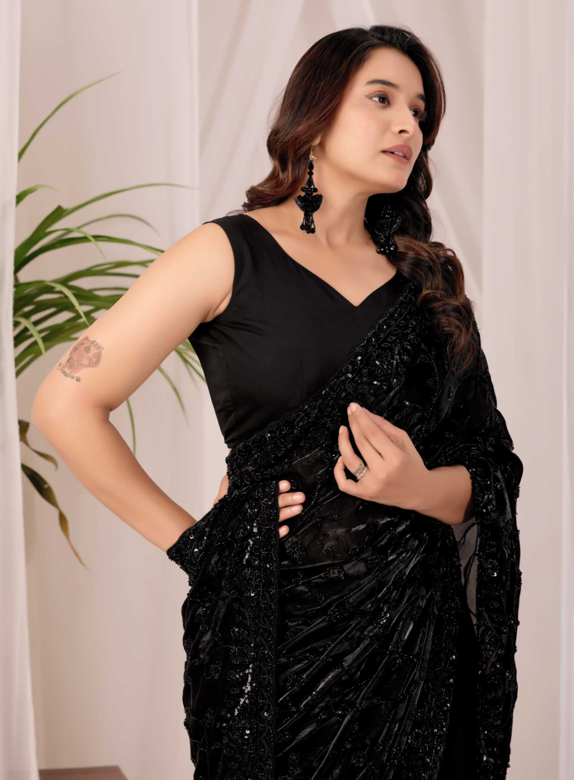 The Black Onyx Sequin Heritage Saree The Black Onyx Sequin Heritage Saree + Embrace the allure of the night with this stunning midnight onyx saree from Kesari Culture. This piece is a masterclass in monochrome elegance, featuring a luxurious black base completely transformed by shimmering tonal sequins. The intricate embroidery creates a subtle yet captivating texture that dances with the light, making it a sophisticated choice for cocktail parties, evening receptions, and high-glamour events. Paired with a sleek, sleeveless V-neck blouse, this ensemble offers a contemporary silhouette while maintaining the timeless grace of traditional attire.